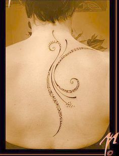 the back of a woman's shoulder with an intricate design on it