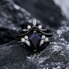 a black diamond ring sitting on top of a rock