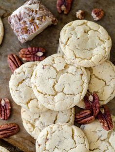 a pile of pecan cookies sitting on top of a table next to some pecans