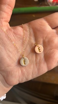 Inspired by Pinterest, I created these neutral beige and pale salmon polymer clay charms that are personalized with the first letter of your name!  The chain is dainty and delicate, 1.3mm oval cable, gold filled, and 18" long closing with a spring ring clasp from GemPacked Jewelry. (GemPacked processing and delivery for chains is 5-7 business days. Thank you for your patience!)  The charm is handmade by me using neutral beige and pale salmon polymer clay and stamped with your letter. I hand painted the letter with gold acrylic paint to add a small amount of glitz.  Polymer clay is a lightweight material, and I used Sculpy Soufflé so it's very durable. If you would like to add on extra charms to make it a mothers necklace, be sure to specify in your order. Polymer Clay Pins Brooches, Polymer Clay Pendant Necklace, Polymer Clay Necklaces, Clay Charms Ideas, Polymer Clay Charms Diy, Polymer Clay Necklace Ideas, Polymer Clay Gift Ideas, Clay Letters, Diy Clay Jewelry