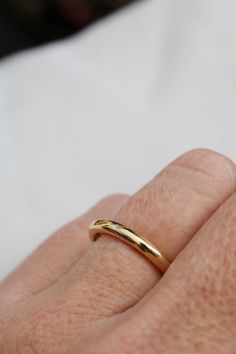 a person's hand with a gold ring on it