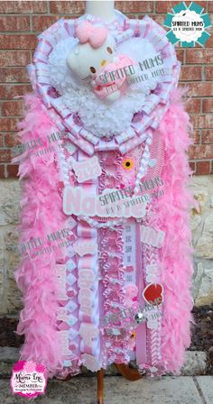 a hello kitty costume made out of pink and white feathers, with a teddy bear on top