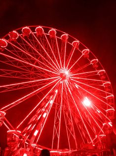 a red ferris wheel lit up at night