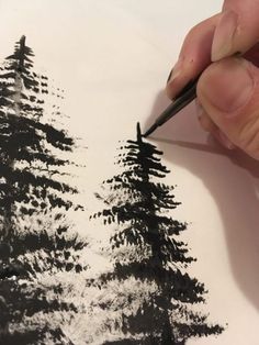 a person is drawing trees with black ink