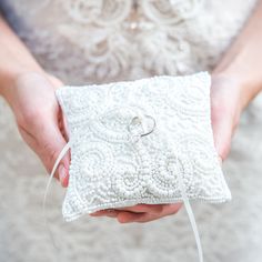 a person holding a white ring pillow in their hands