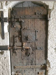 an old wooden door with metal handles and latches