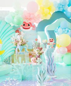 an under the sea themed birthday party with balloons, decorations and other items in pastel colors