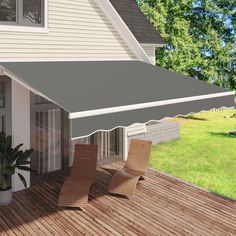 an awning on the outside of a house with two chairs and a potted plant