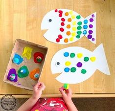 a child is playing with some paper fish