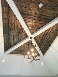 a ceiling with wooden planks and chandelier