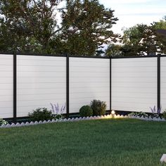 a white privacy fence in the middle of a grassy area