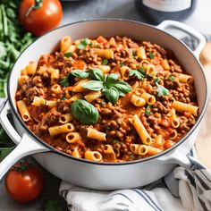 a pot filled with pasta and sauce on top of a wooden table next to tomatoes