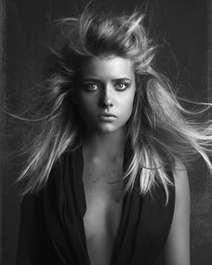 a woman with long hair is posing for a black and white photo