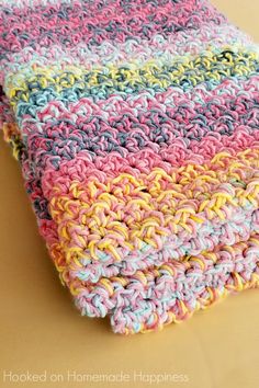 a multicolored crocheted dishcloth is laying on top of a table