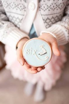 a person holding a small blue object in their hand with the word six on it