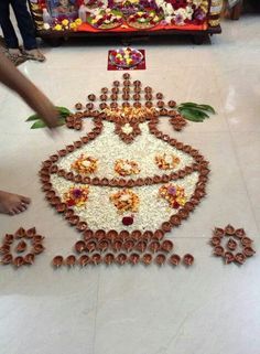 someone is decorating the floor with chocolates and flowers on it for diwaling