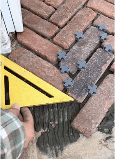 a man is working on a brick walkway