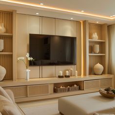 a living room filled with furniture and a flat screen tv mounted on a wall next to a window