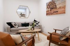 a living room with two couches, a coffee table and pictures on the wall