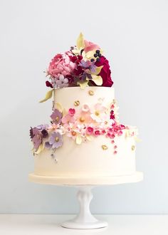 a three tiered white cake with flowers on top