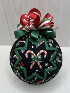 a christmas ornament with candy canes on it's top and bow