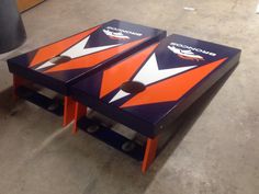 two orange and blue tables sitting on top of each other in a room with concrete flooring