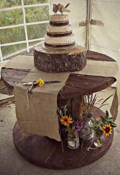 there is a table made out of wood and burlocks with flowers on it