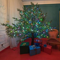 a small christmas tree with presents under it