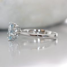 A single oval Antique Modified brilliant 9x7 mm ocean blue Aquamarine is set creatively in the center of a basic solid 14k white gold with two VS diamond on each side of a knife edge band. This eight-prong setting is perfect for a spectacular night out with your love ones. *Style # R101E-9x7Aqua-14K/W Center Stone*Natural AAA Quality Aquamarine*Aqua Blue, Eye-clean (VS1 clarity) *9x7mm Oval Brilliant cut *Approx. gemstone weight: 1.60 caratsSide Stone *Conflict Free Natural White Diamonds*Round Oval Topaz Promise Ring With Polished Finish, 14k White Gold Oval Topaz Ring, Oval Blue Topaz Ring With Polished Finish, Oval Solitaire Topaz Ring In White Gold, White Gold Oval Solitaire Topaz Ring, Oval White Gold Topaz Solitaire Ring, Ring Shank, Vs Diamond, Detailed Ring