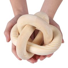 a person holding a large wooden knot in their hands with both hands on top of it