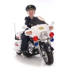 a young boy in uniform is sitting on a police motorbike and posing for the camera