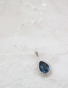 "This sparkly necklace has been made with a custom frame, only available in our shop! The rhodium plated frame has around 20 small clear cubic zirconias and the focal is a sparkly Montana Blue color Swarovski teardrop. This luxury necklace is perfect for a fancy night out, great as focal point of your outfit or for Bridesmaids gift.  The swarovski teardrop crystal measures 18mm and the whole pendant including the Cubic Zirconia Drop setting about 1\" (25mm) in total length. Comes on a 18 inch st Blue Halo Setting Necklace For Wedding, Blue Necklace With Halo Setting For Wedding, Sapphire Halo Setting Necklace For Wedding, Sapphire Necklace With Halo Setting For Wedding, Blue Wedding Necklace, Navy Necklace, Statement Earrings Wedding, Blue Pendant Necklace, Bridal Earrings Chandelier