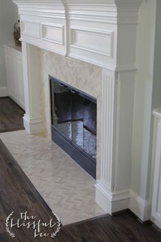 an image of a fireplace in the middle of a room with wood floors and white walls