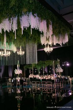 an elaborate chandelier hangs from the ceiling above tables with chairs and centerpieces