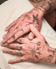 a person's hand with tattoos on it