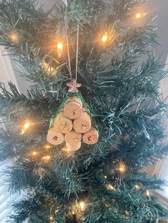 a small christmas tree with several pieces of wood hanging from it's side and lights on the top