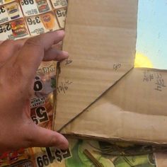 a hand is pointing at an envelope with nails on it and other money in the background