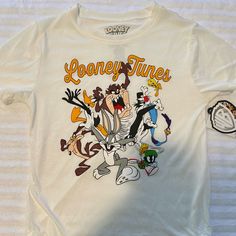 Looney Tunes Tee Shirt Sz Xs Nwt White. Measurements Approximate While Lying Flat 16.5” Armpit To Armpit 6” Sleeves 24.5” Long Loony Tunes Shirt, White Graphic Tee With Cartoon Print, White Cartoon Print Graphic Tee, White Graphic Print Fun Top, Fun White Top For Streetwear, Fun White Tops For Streetwear, Retro White Shirt With Character Print, White Retro Tops With Character Print, Hufflepuff Shirt