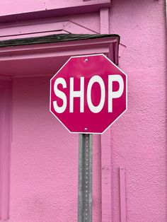 a stop sign in front of a pink building