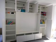 a room with white shelves and drawers in it