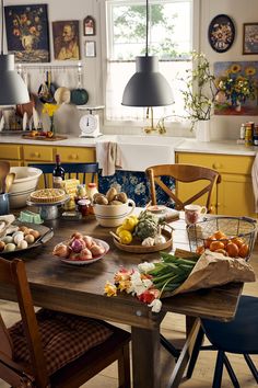 a wooden table topped with lots of fruit and veggies next to a window