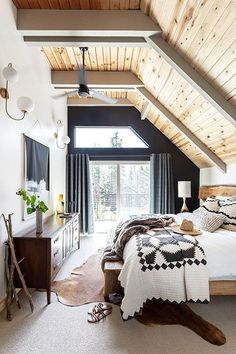 a bedroom with a large bed and wooden ceiling