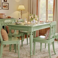 a dining room table and chairs in front of a window