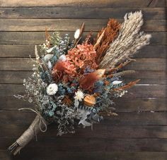 a bouquet of dried flowers on a wooden surface