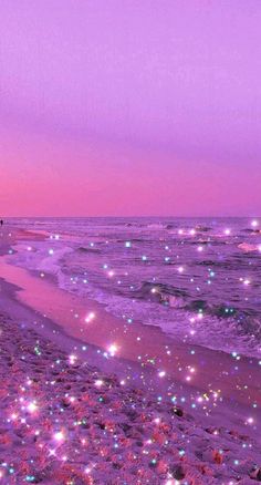 the beach is covered in purple and green lights at night, as well as stars on the sand