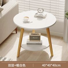 a white table with some books and a clock on it in front of a window