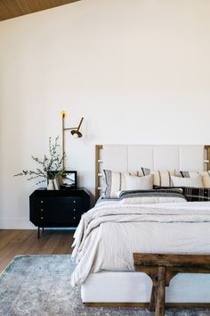 a bedroom with white walls and wooden floors