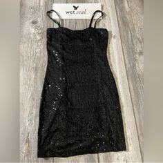 a black dress with sequins on it and a sign hanging from the back