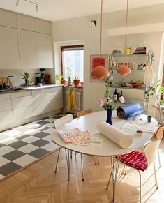 a kitchen area with a table, chairs and shelves