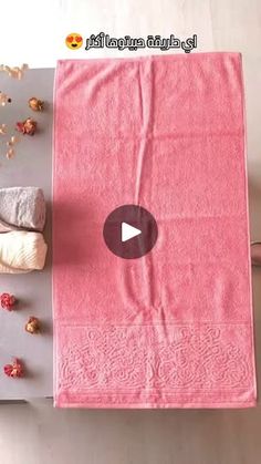 a pink towel sitting on top of a cutting board next to a bowl of popcorn